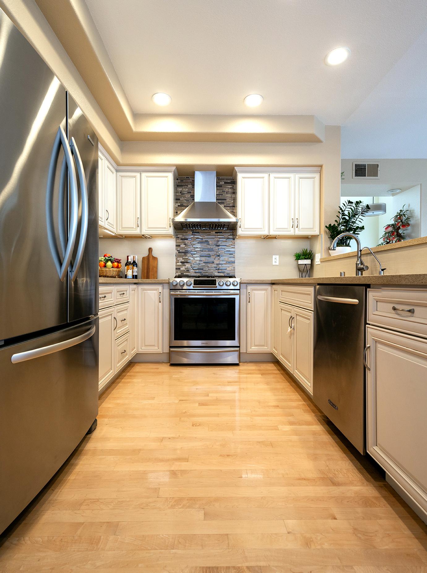 Remodeled kitchen with new cabinets, countertops, backsplash, appliances, and lighting.